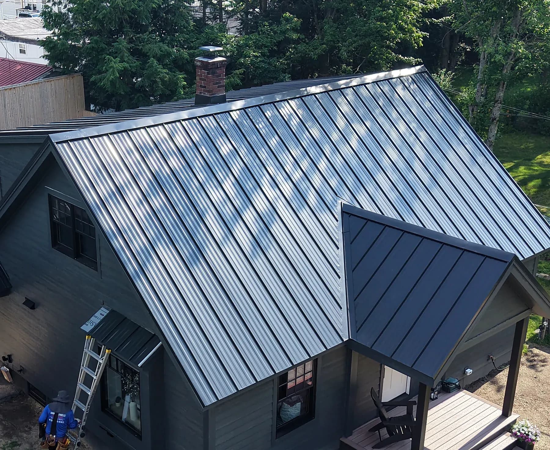 Completed matte black standing seam metal roof on a home in Brunswick, Maine by GraniteShield Roofing & Exteriors