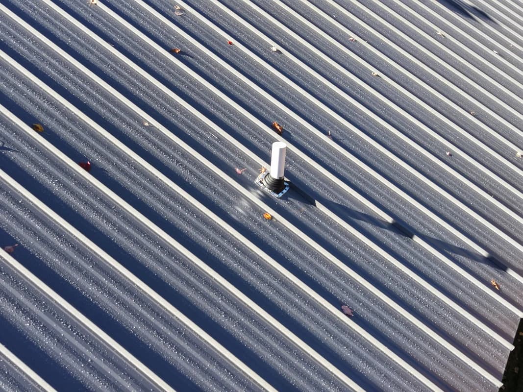 Aerial view of completed metal roof installation in Maine during fall - standing seam roofing