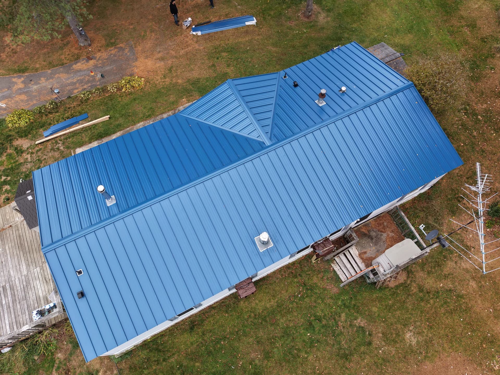Blue standing seam metal roof installation in Maine - aerial drone view of completed metal roofing project